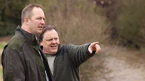 Richard Foord talking to a local resident by a dirty river