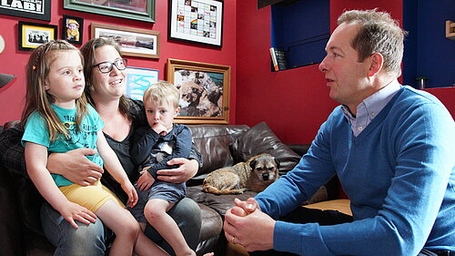 Richard Foord sat chatting to a mother with two young children on her lap